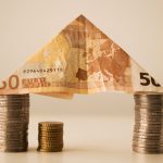 model domu utworzony z monet i banknotu