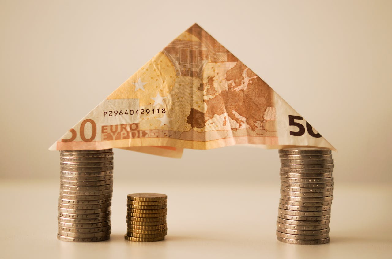model domu utworzony z monet i banknotu